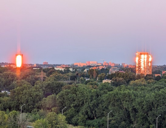 Sunrise reflecting blazing light on the windows of an office tower. 