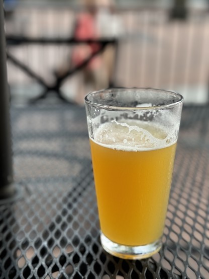 A pint of beer on a black cafe table. 