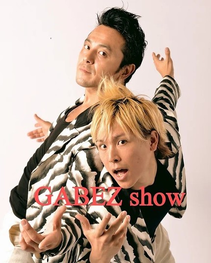 Gabez. Japanese comedy dance mime artists. Two Japanese men in Zebra pattered jackets. One has bleached blonde hair.