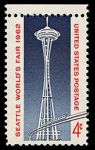 A United States postage stamp commemorating the Seattle World's Fair in 1962. The stamp has a face value of 4 cents. The stamp depicts the Space Needle, with a monorail train swooping out of the structure and seeming to run off of the stamp.