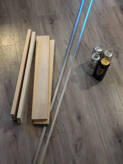 Wooden planks, metal L extrusions and 4 cans of   beer sit on my floor - ready to be assembled into a camera slider