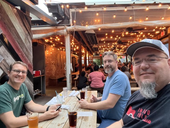 Three people sitting at an outdoor table at a restaurant 