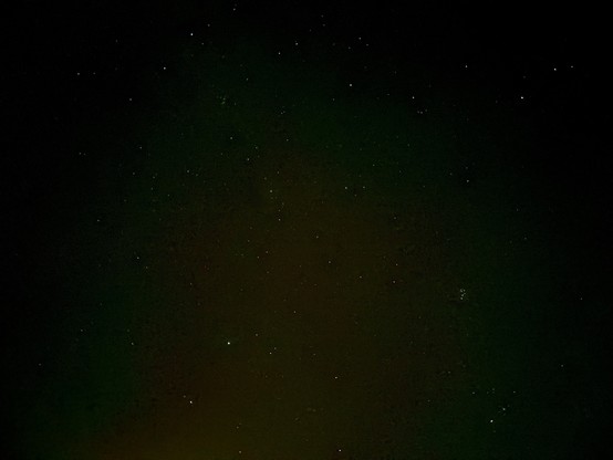 A starry sky with a green and orange tint