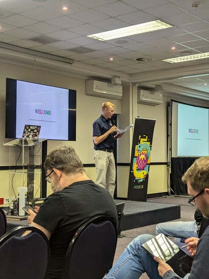 James Smith on a stage, opening PyConZA 