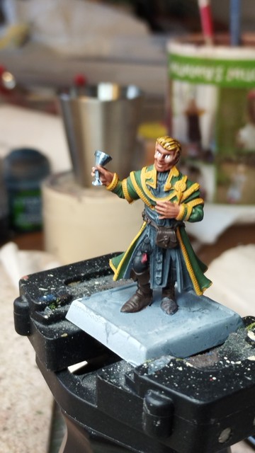 Miniature, painting work in progress... Smiling man in cloak, non metallic metal goblet in his hand.