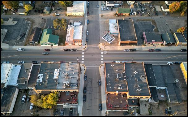 Looking down on the rooftops of several two story buildings on the main street of a small town. 