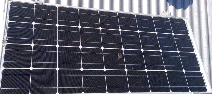 a solar panel on a corrugated iron roof showing cracking in most of the cells.