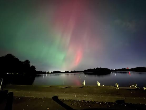 Red green aurora over a lake