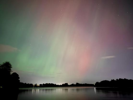 Red green aurora over a lake