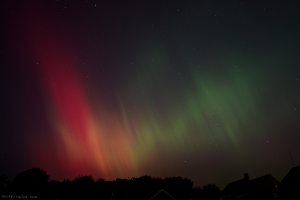 Red and green aurora patterns in the night sky.