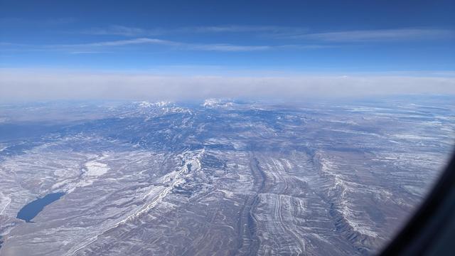 the foothills of the rocky mounrains extending to snow capped peaks, ripples etched across the earth