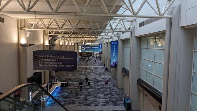 convention center hall, signs for kubecon can be seen