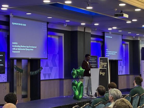 Bhuvnesh on stage, with slides behind him - Zango: Accelerating Business App Development with an Opinionated Django Meta-Framework