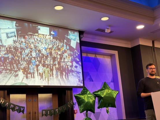 Paolo on stage. Slide shows the group photo from DjangoCon Europe in Copenhagen 