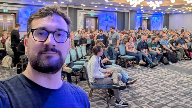 Me taking a selfie in front of a room full of people 