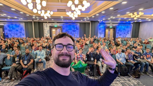 Me taking a selfie in front of a room full of people 