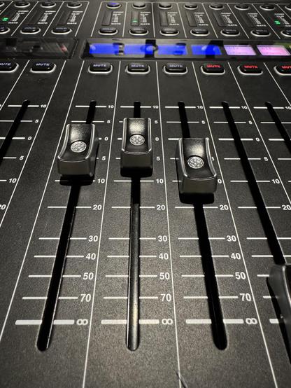 Three faders on a Midas M32 console 