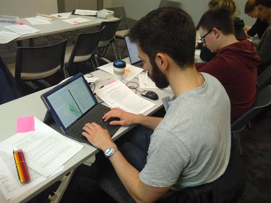 Student working on a tablet computer making a map.