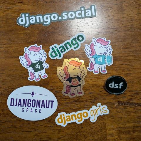 A pile of Django logo and pony stickers on a kitchen table