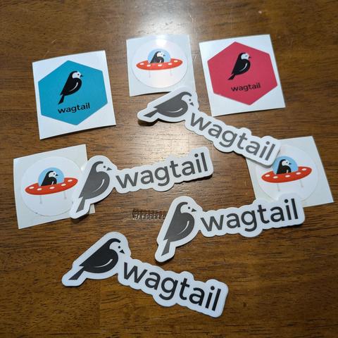 A pile of Wagtail bird stickers on a brown kitchen table
