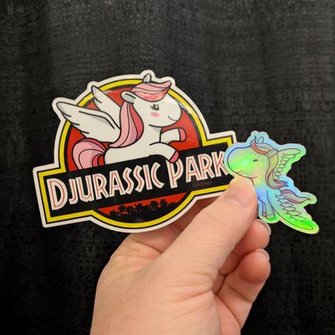 A hand holding two holographic pony stickers stickers.
