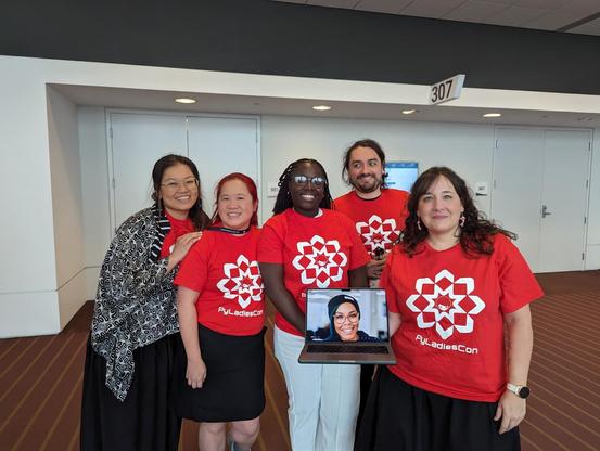 Team photo of PyLadiesCon, each wearing the red PyLadiesCon T-shirt. Left to right: Georgi Ker, Mariatta, Abigail Dogbe, Cristián Maureira-Fredes, Maria Jose Molina. Denny Perez is joining us via laptop.

Photo taken by Ned Batchelder