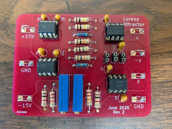 A red printed circuit board populated with integrated circuits, resistors, and capacitors. The upper right corner reads "Lorenz Attractor" and the lower right corner reads "June 2025 Rev 2".