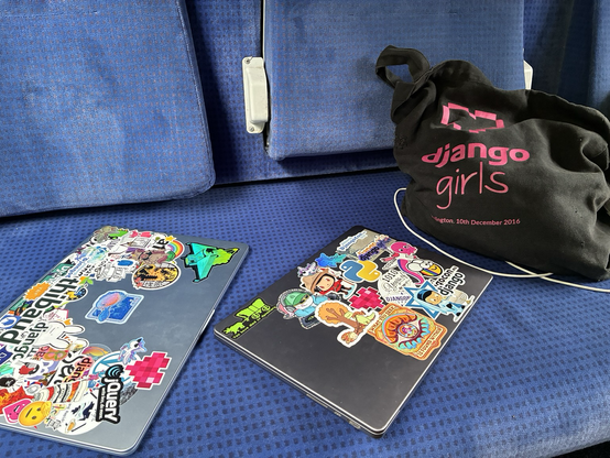 Laptops with stickers on a train seat