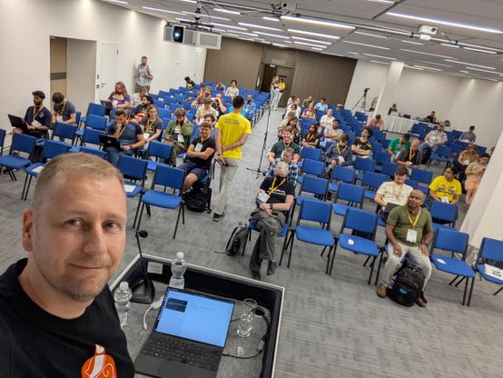 Selfie with the audience in the background, minutes before my talk. 