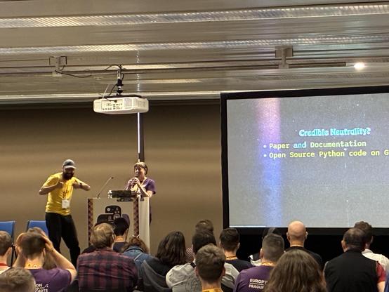 Andy and Laura on stage next to their slides