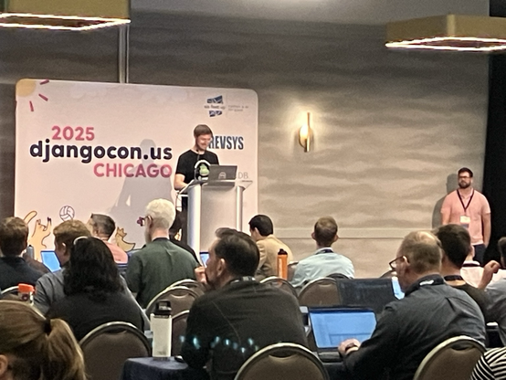 Adam G Hill at the podium giving a lightning talk.