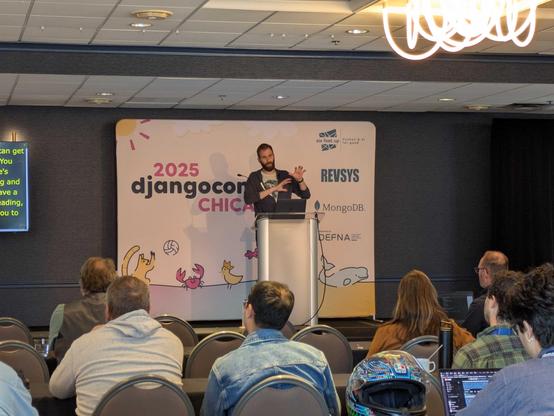 Michael Trythall speaking on stage at DjangoConUS.
