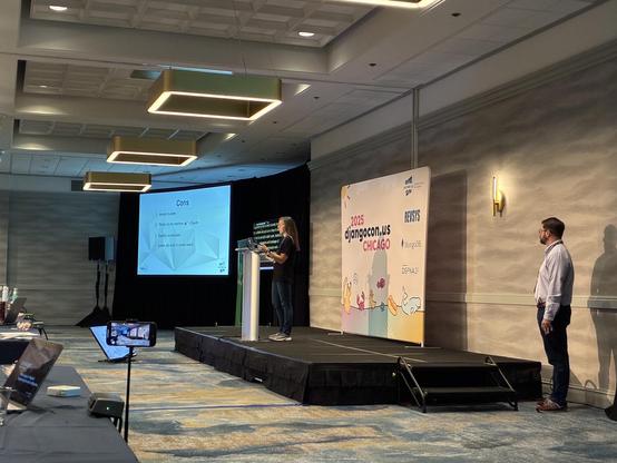 Chrissy on stage introducing the cons with AI coding