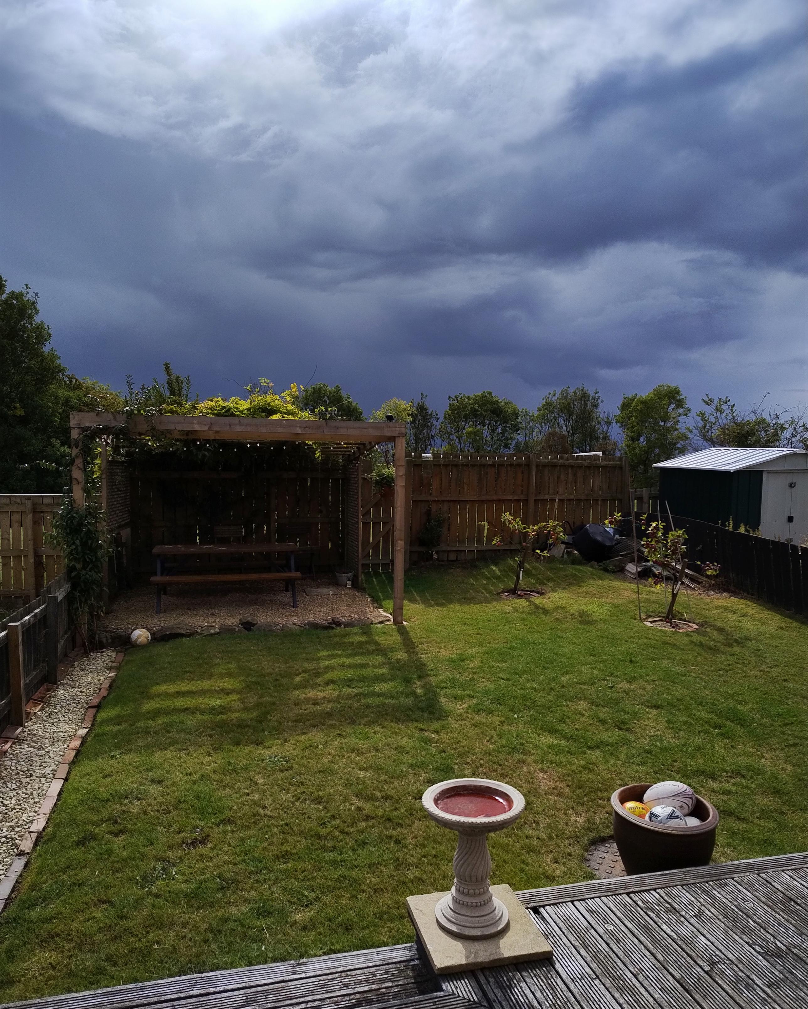 Sunny back garden, with brooding skies above... suggesting it may not be sunny much longer!