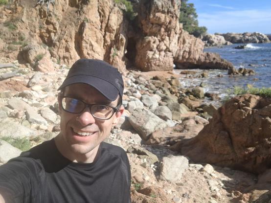 Tired Mariusz with the rocky beach in the background.
