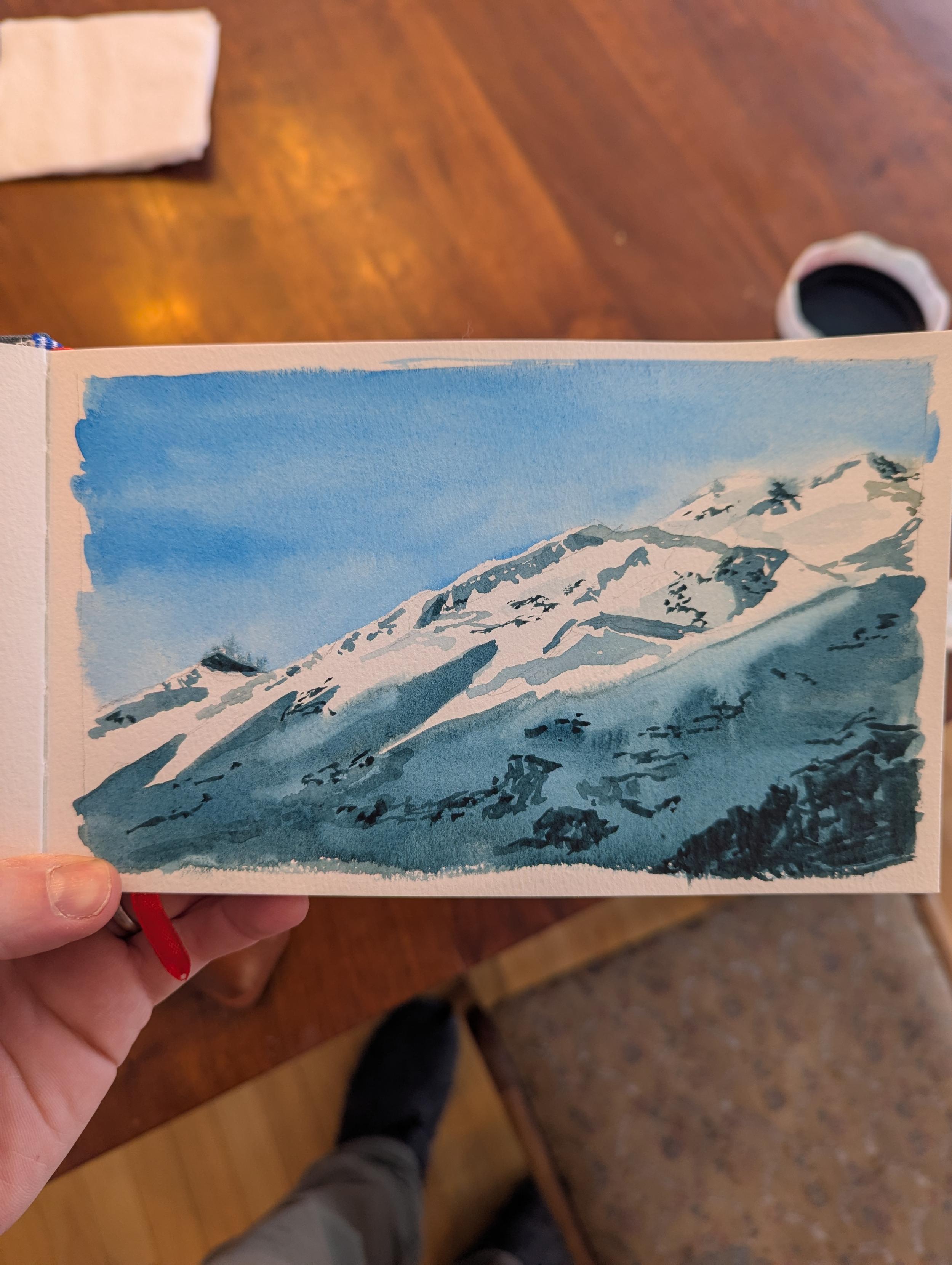 A snowy mountain against a bright blue sky. A deep shadow covers the lower half. 