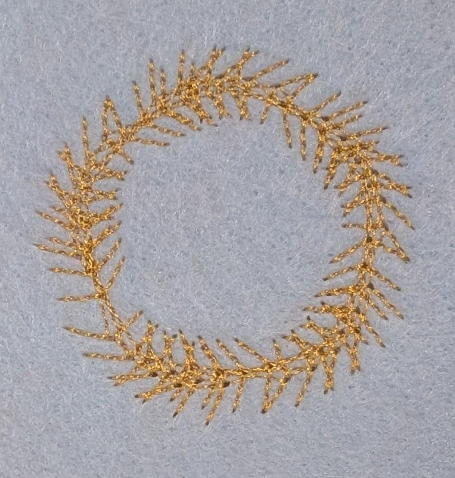 A stitched pattern, it is circular pattern with 'branches' going round the outside and side of the circle.