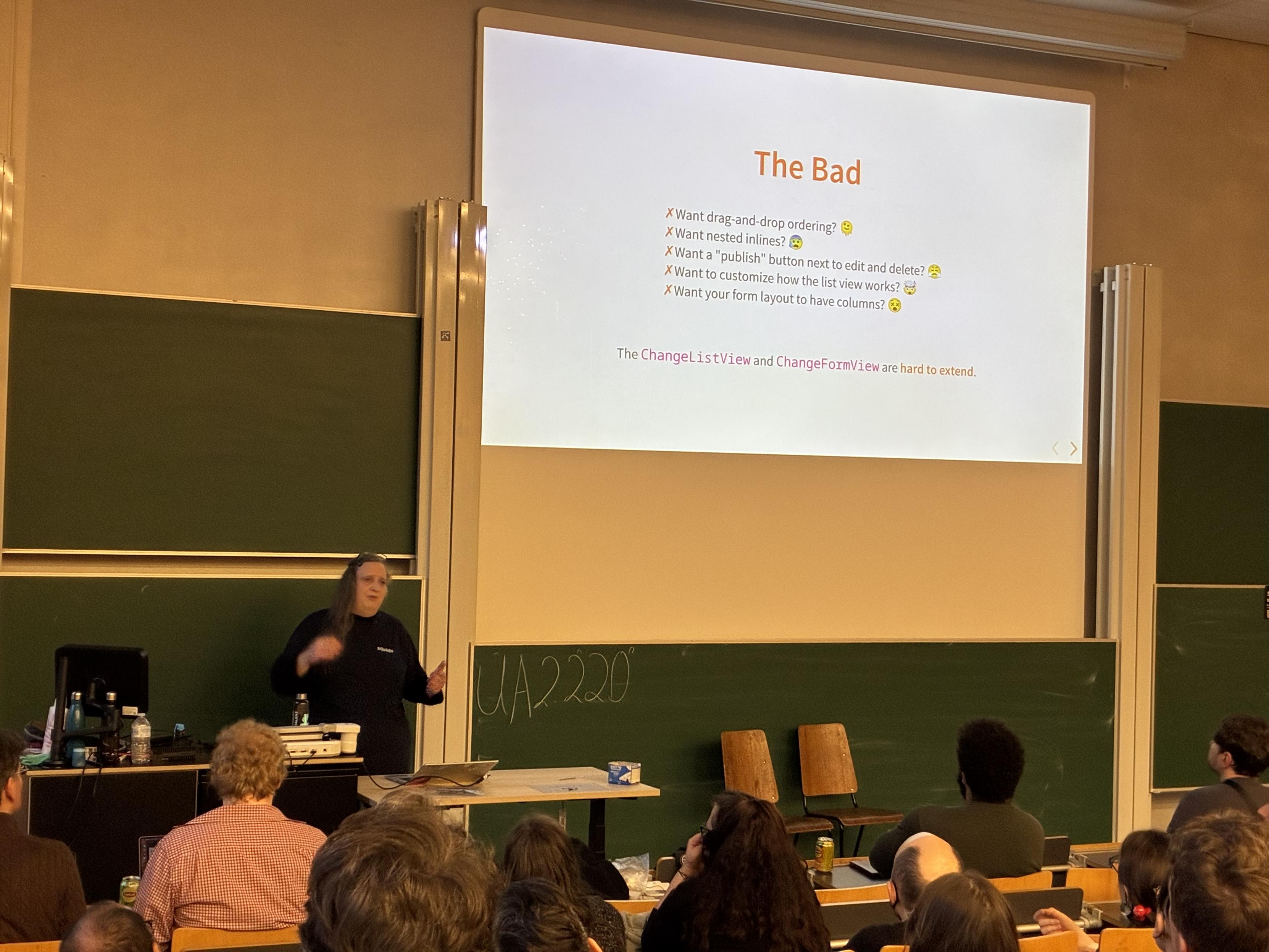 Emma on the stage with a slide about "The Bad" aspects of the admin