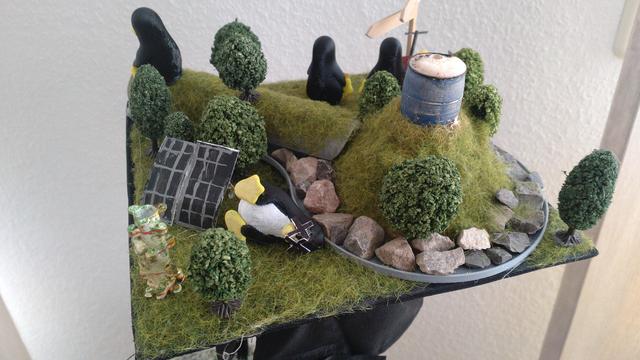 another angle, one of the penguins lies dead on the floor (from the CO2-emitting mofettes), on a hill there's a blue barrel where red baking soda volcano foam came out