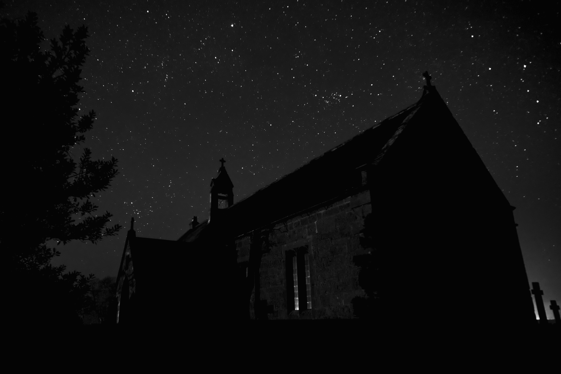 Night sky with a church in the foreground, field of stars behind.