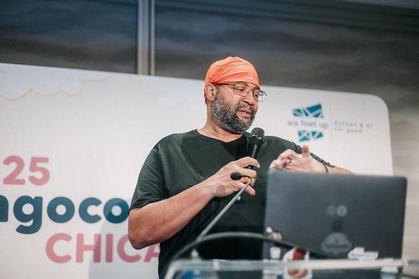 Kojo checks the time from the stage at DjangoCon US 2025