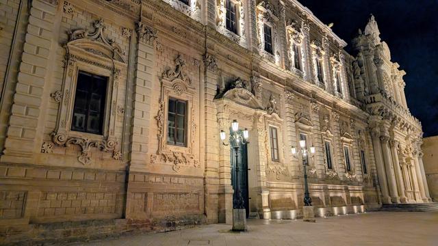 Night view of the historic center of Lecce, with the Church of Santa Croce beautifully illuminated during an evening walk.