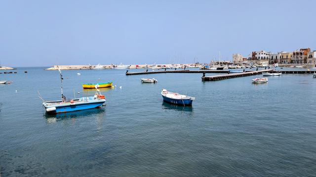 View of the port of Santo Spirito near Bari, with boats and the calm sea under daylight.