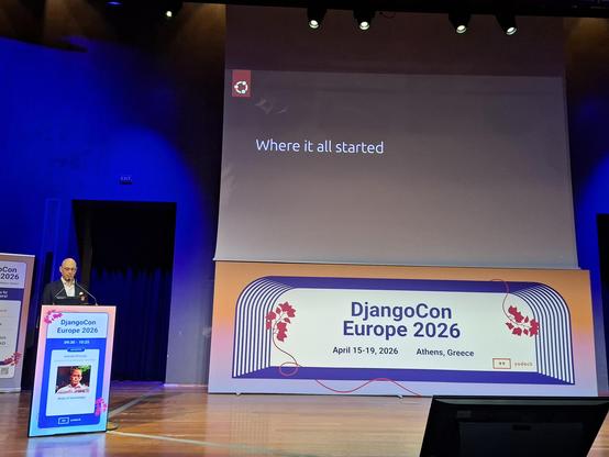 Big screen with "where it all started" text, and Daniele Procida on the stage.