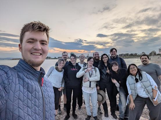 Group photo with other conference attendees at Glyfada beach in Athens, the bay is in the background