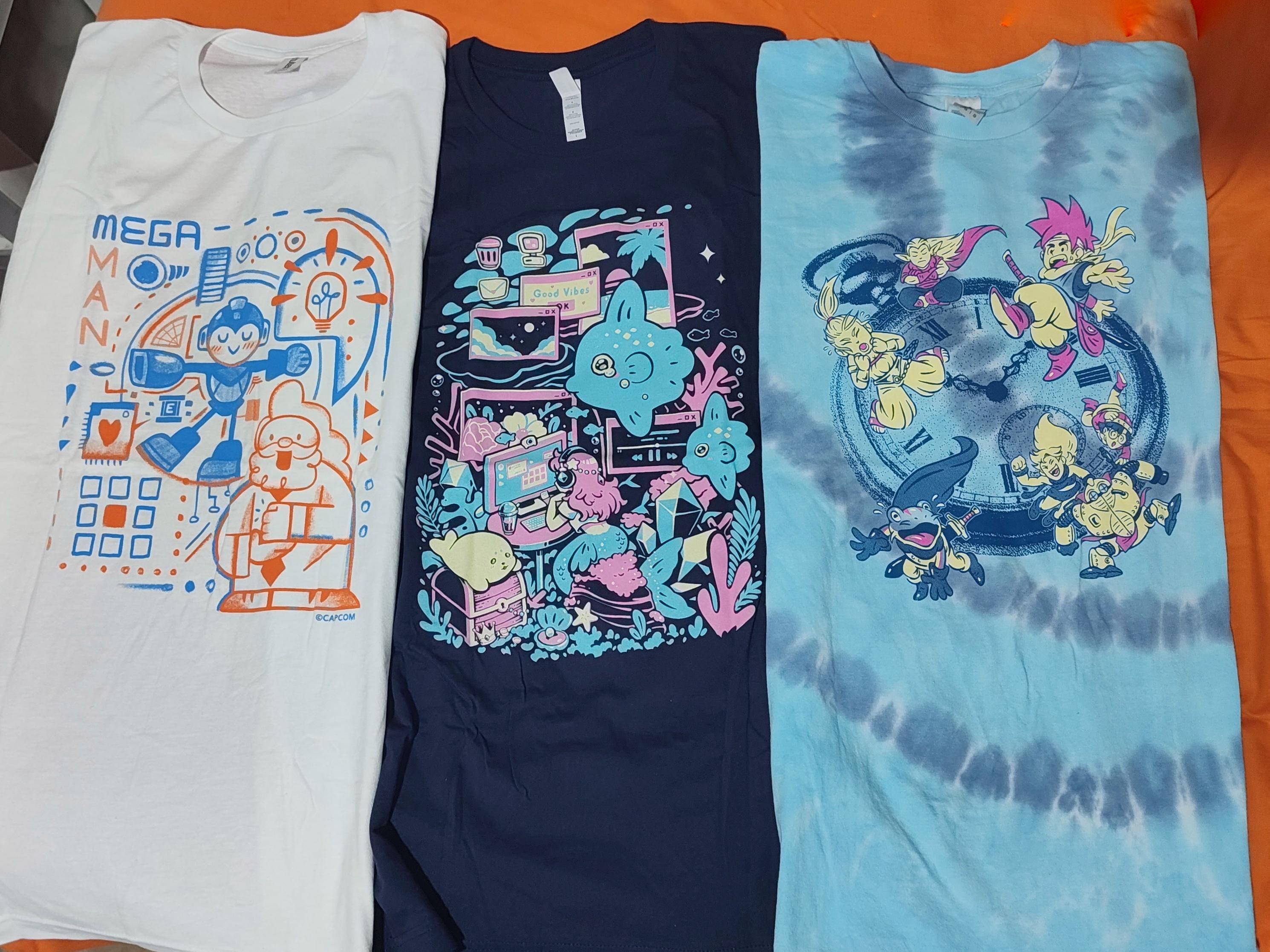 A shirt of Megaman, or some mermaid using a computer, and of the Chrono Trigger characters warping through time