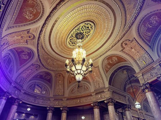 Looking up at the incredibly opulently decorated rotunda of the Rialto, with the fantastic, massive central chandelier as its focus.