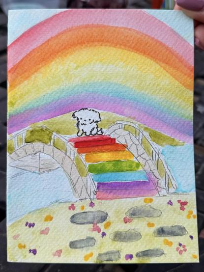 Watercolor painting of a small white dog, looking back at us while sitting on a small stone bridge that is paved in rainbow colors.