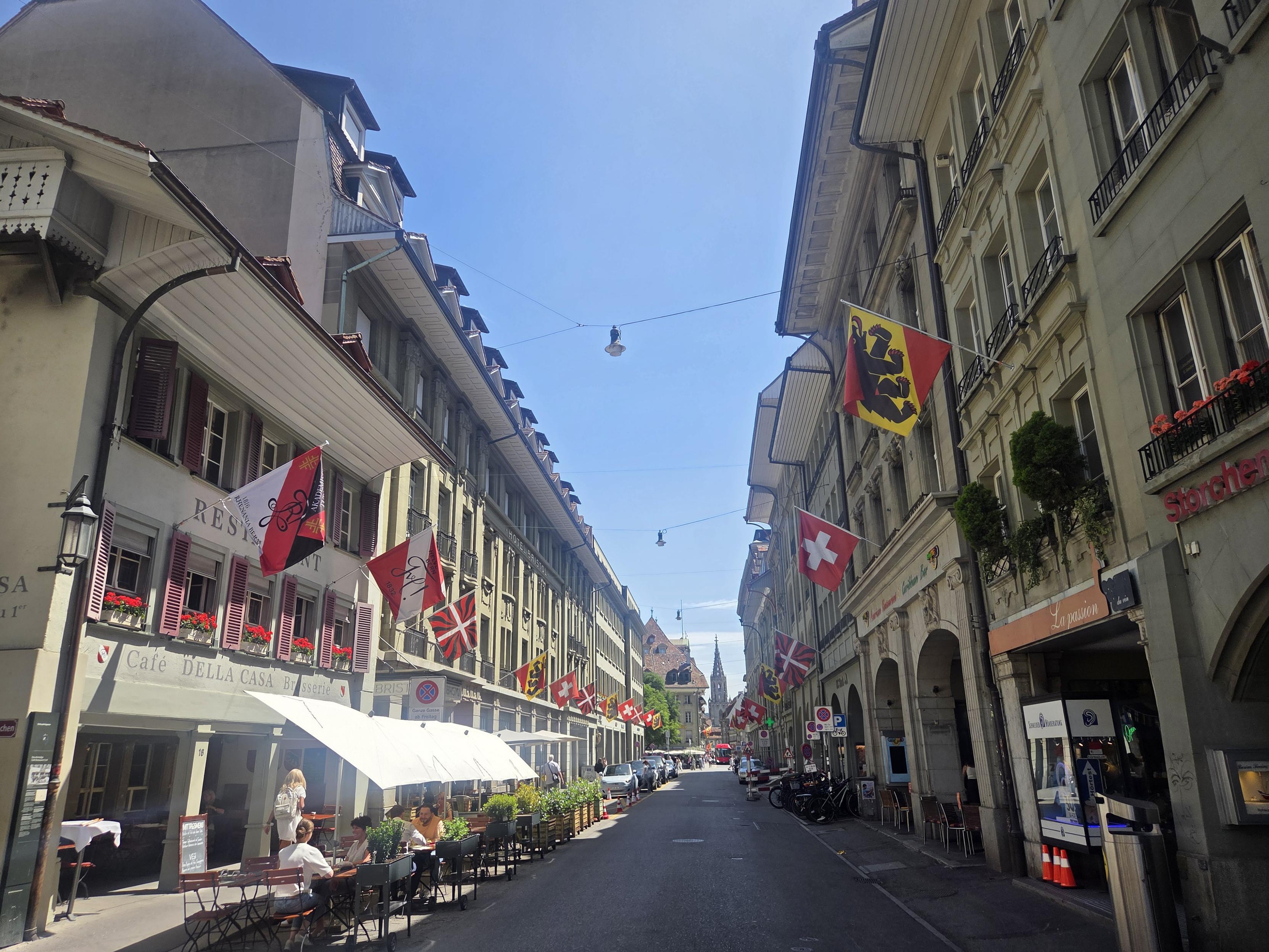 A street in Bern with flags everywhere and a church at the end
