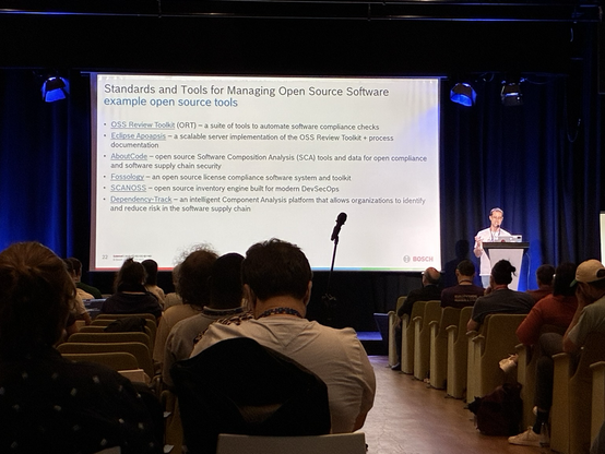Vladimir on stage next to his slide about tools